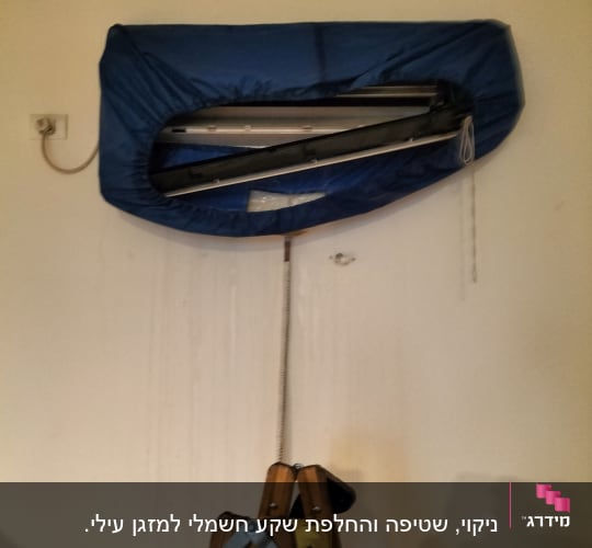 מזגן מכוסה בכיסוי כחול עם סולם עץ מתחתיו